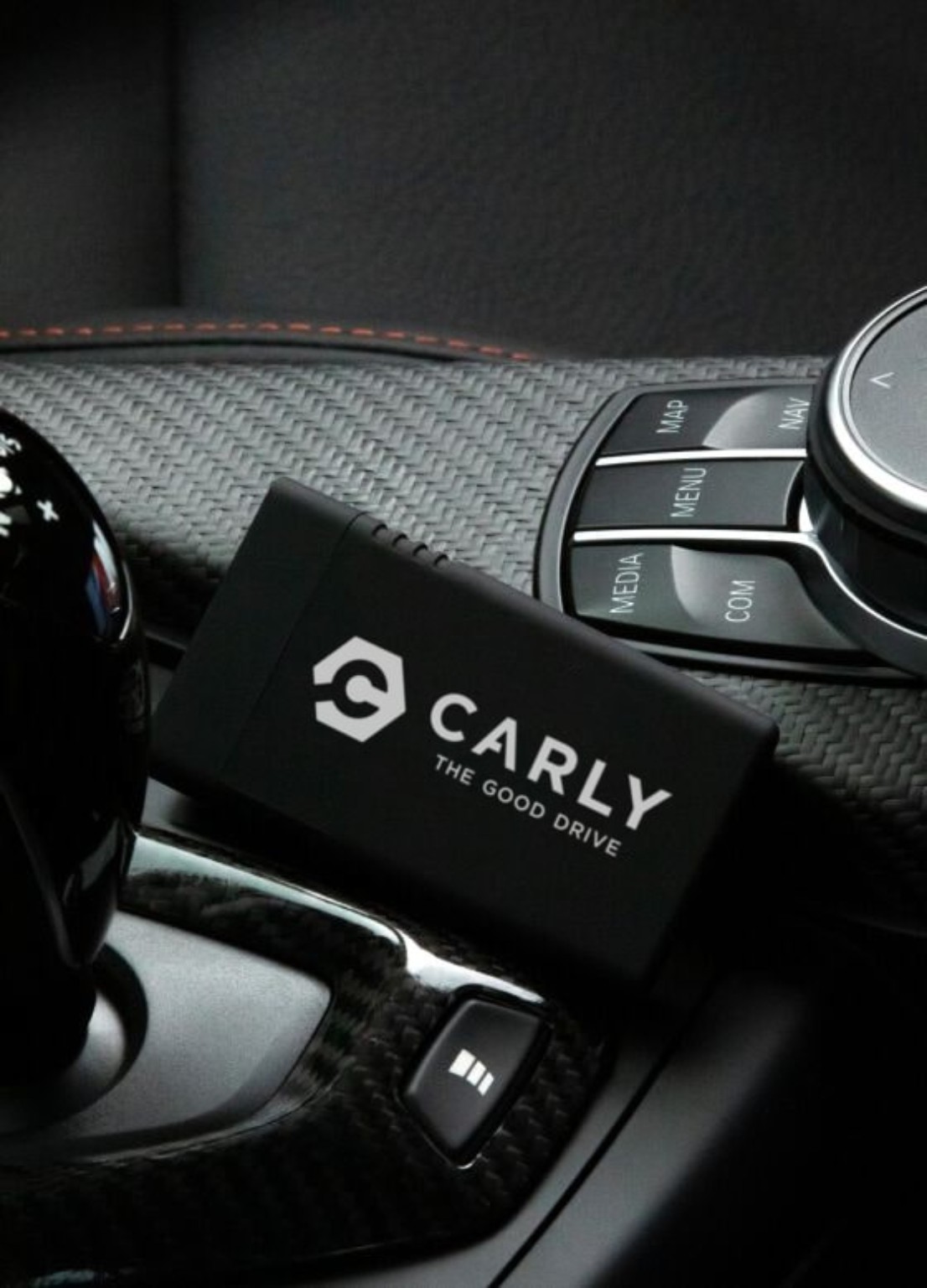 Carly scanner beside a vehicle centre console